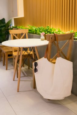 Güneş gözlüğü ile bulanık tuval çanta sandalye oturma odasında bekle