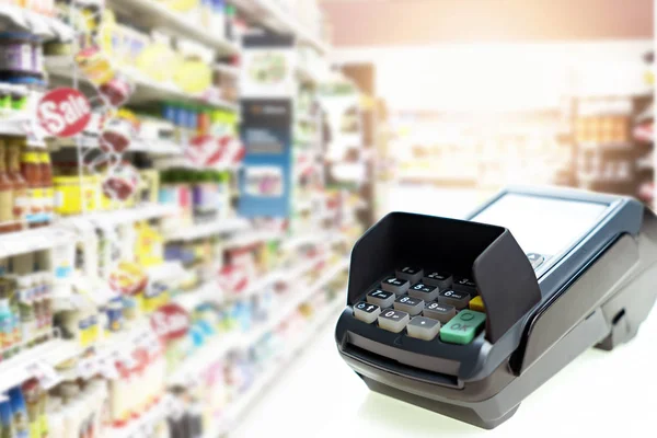 Bulanık süpermarket geçmişindeki kart makinesi. İş konsepti