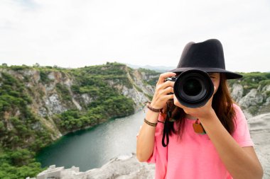 Profesyonel kadın fotoğrafçı doğa fotoğrafı çekiyor.