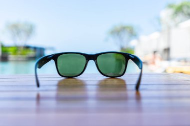 Sunglasses on wooden table at the beach