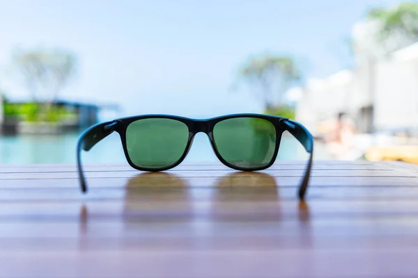 Gafas de sol sobre mesa de madera en la playa —  Fotos de Stock