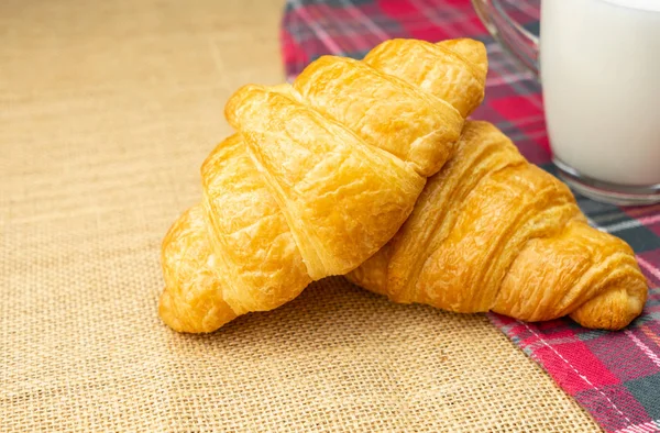 Croissant-Haufen mit Milch auf dem Tisch zum Frühstück — Stockfoto