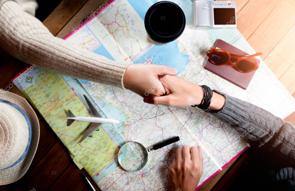 Woman with friend planning for vacation trip with accessories 