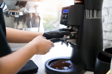 Barista kafede kahve makinesiyle kahve yapıyor.