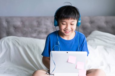 İnternette oyun oynamak veya eğitim almak için dizüstü bilgisayar kullanan küçük çocuk