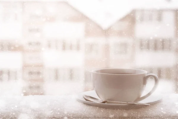 Cup of hot tea outdoor in snowing day.