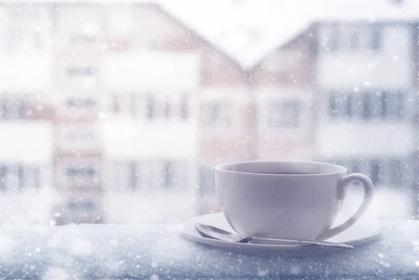 Cup of hot tea outdoor in snowing day.