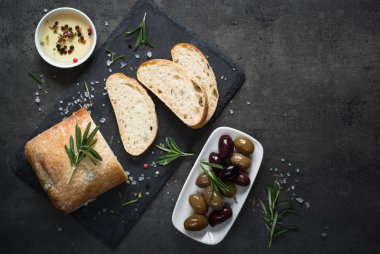 İtalyan ciabatta ekmeği üzerinde siyah barut otlar ve zeytin ile.