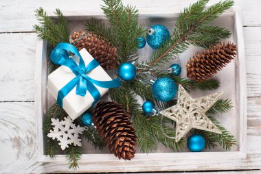 Noel arka plan. Mavi dekorasyon koniler, beyaz kutu hediye.