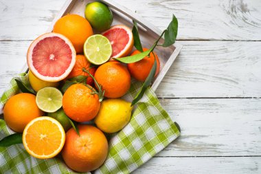 Narenciye meyve içinde beyaz masada ahşap tepsi.