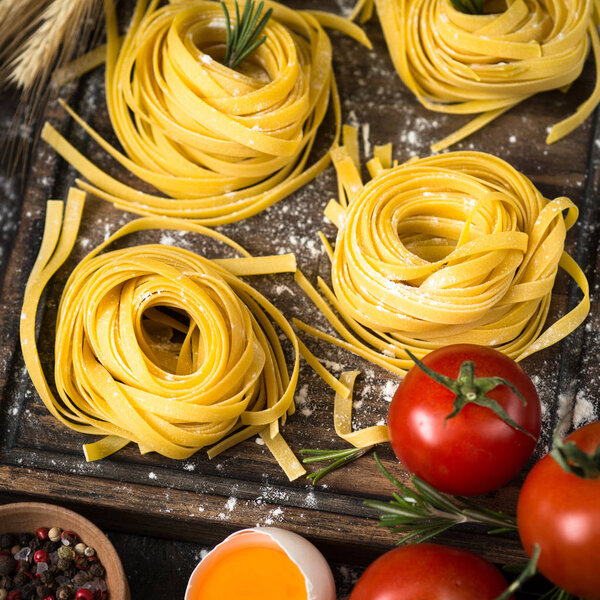Fresh raw pasta tagliatelle and ingredients