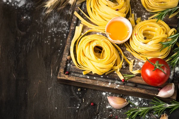 Fresh raw pasta tagliatelle and ingredients — Stock Photo, Image