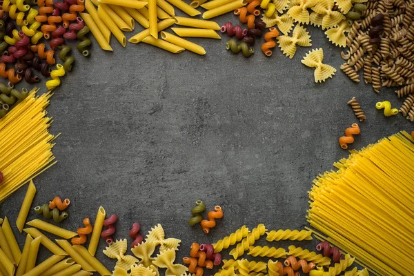 Various types of pasta - spaghetti, penne, fusilli, colored vege