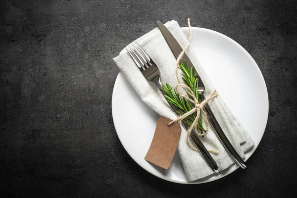 Configuração da mesa. faca de garfo e placa branca na mesa de ardósia escura . — Fotografia de Stock