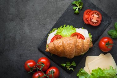 Kruvasan sandviç jambon, peynir, marul ve domates ile