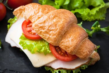 Kruvasan sandviç jambon, peynir, marul ve domates ile