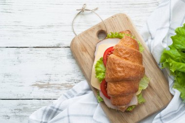 Kruvasan sandviç sosis, peynir, marul ve domates ile