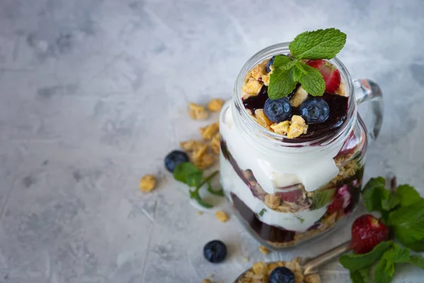 Yogurt granola jam berries dessert in mason glass jar.