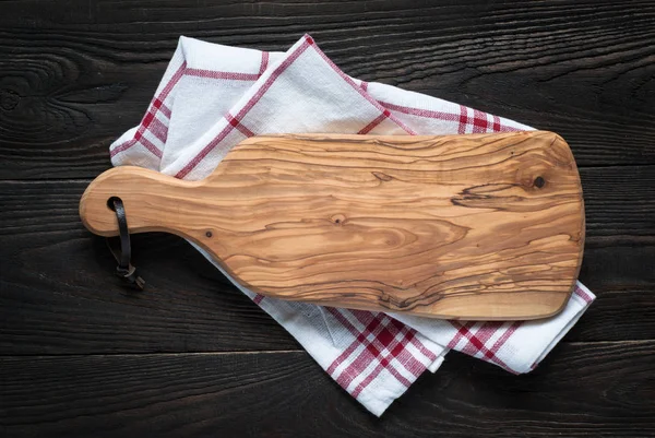 Snijplank op donkere houten tafel. — Stockfoto