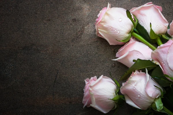 Růžové růže u kamenného stolu. — Stock fotografie
