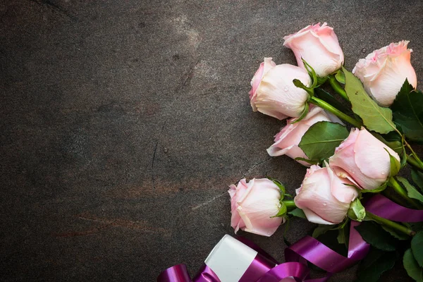 Růžové růže u kamenného stolu. — Stock fotografie