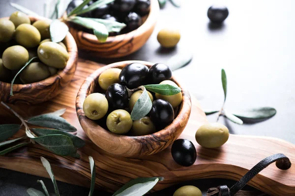 Чорно-зелені оливки в дерев'яній мисці — стокове фото