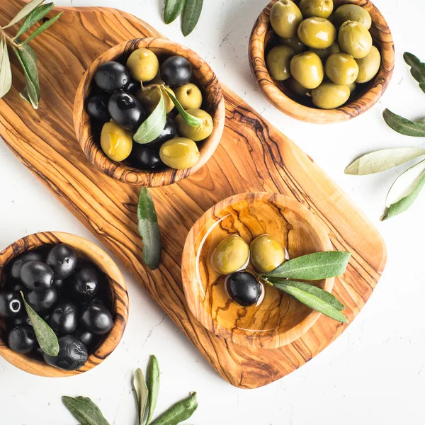 Svarta och gröna oliver på vit. — Stockfoto