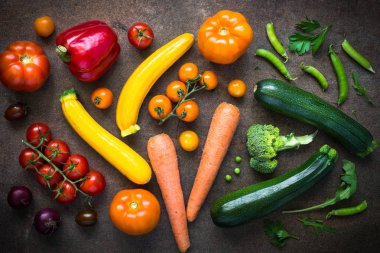 Karanlık taş masada çiğ sebze yelpazesi.