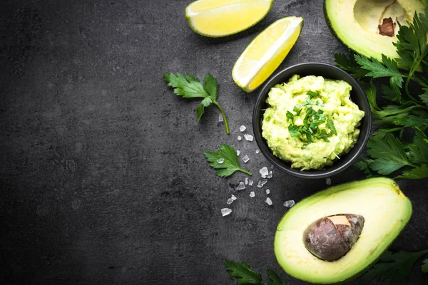 Traditionelle latinamerikanische mexikanische Sauce Guacamole auf Schwarz. — Stockfoto