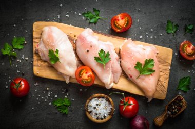 Çiğ tavuk fileto et kesme tahtası üzerinde.