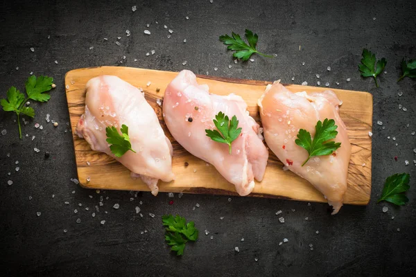 Çiğ tavuk fileto et kesme tahtası üzerinde.