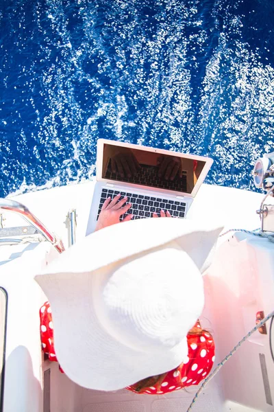 Woman freelancer on a sailboat with a laptop computer. — Stock Photo, Image