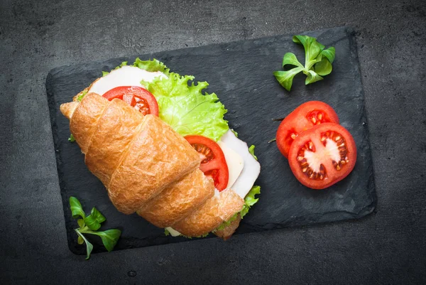 Croissant, szendvics sonka, sajt, saláta és a paradicsom — Stock Fotó
