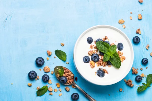 Mavi masada bir yaban mersini ve Yunan yoğurt granola.