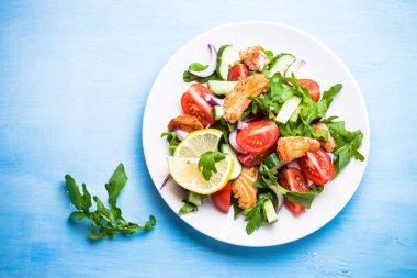 Taze salata somon ve sebzeler mavi.