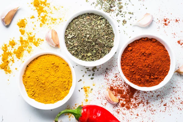 Beyaz arka plan üzerine bir kase içinde çeşitli baharatlar. 