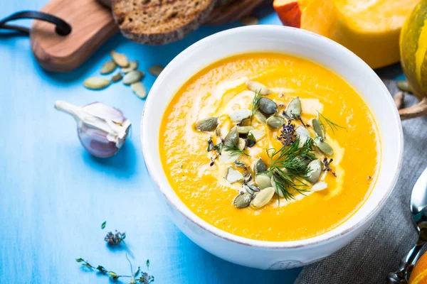 Pompoen en wortel crème soep op blauw. — Stockfoto