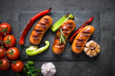 Fried Barbekü sosis siyah arka plan, sebzeli