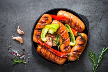 Fried Barbekü sosis siyah arduvaz masada sebzeli.