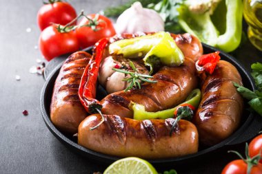 Fried Barbekü sosis taş masada sebzeli.