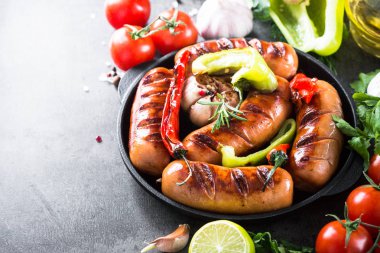 Fried Barbekü sosis taş masada sebzeli.