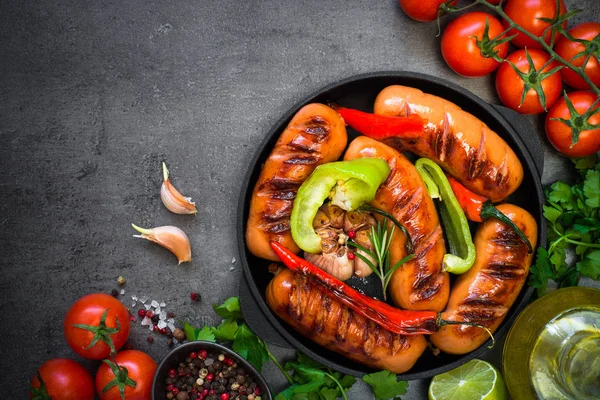 Fried Barbekü sosis siyah arduvaz masada sebzeli.