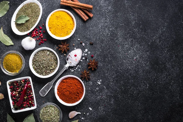 Siyah taş masanın üzerinde çeşitli baharatlar ayarla.