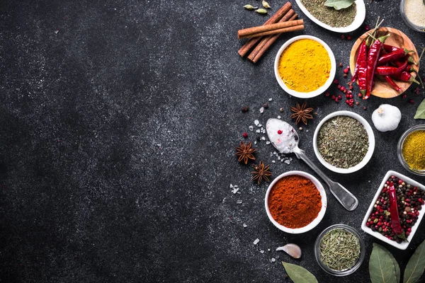 Siyah taş masanın üzerinde çeşitli baharatlar ayarla.