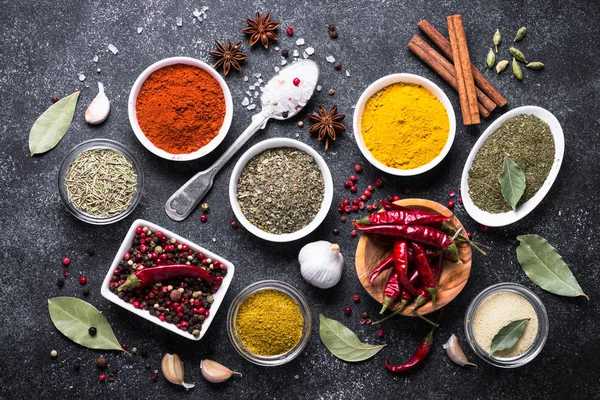 Set van verschillende kruiden op zwarte stenen tafel. — Stockfoto