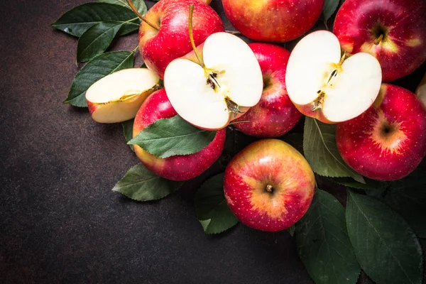 Manzanas rojas con hojas en la mesa. — Foto de Stock