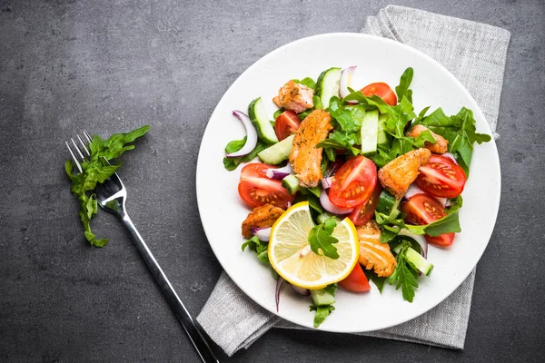 Ensalada fresca con salmón y verduras sobre fondo negro . —  Fotos de Stock