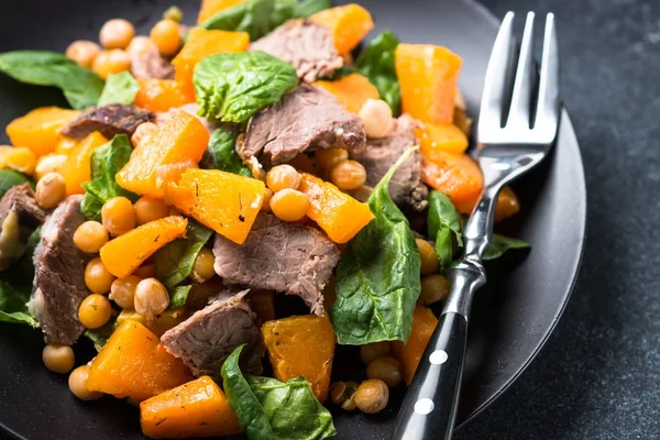 Warm salad with pumpkin, baked beef, spinach and chickpeas. — Stock Photo, Image