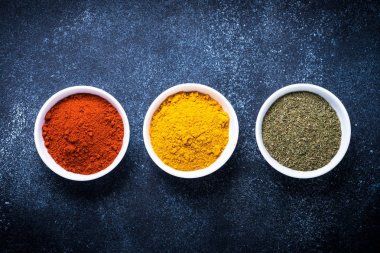 Taş masada bir kase içinde çeşitli baharatlar. 