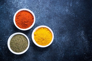 Taş masada bir kase içinde çeşitli baharatlar. 